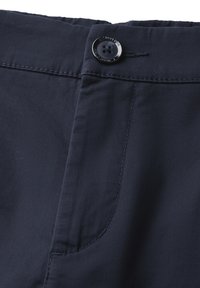 Marineblaue Hose mit glatter Textur, ausgestattet mit einem einzelnen schwarzen Knopfverschluss und sichtbaren Nähten entlang des Taillenbundes und der Tasche.