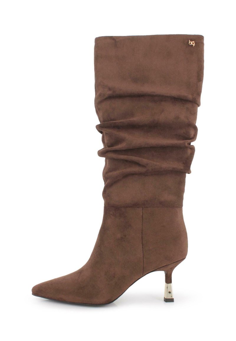 Bota de ante marrón hasta la rodilla con un diseño arrugado, puntera afilada y un tacón esbelto que presenta un acento metálico en la base del tacón.