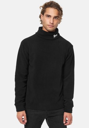 Sort fleece turtleneck med lange ærmer, der har en rullet krave og et lille broderet design på halsen. Glat tekstur.