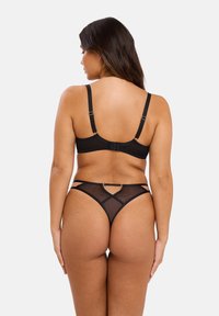 Ensemble de lingerie noir comprenant un soutien-gorge avec des bretelles ajustables et un fermoir à l'arrière, associé à un string avec des détails en maille et des motifs géométriques.