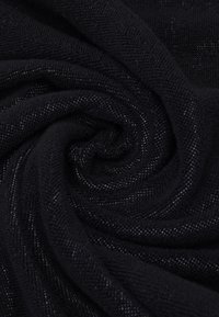 Tissu noir avec une finition douce et texturée, présentant un éclat subtil et un tissage délicat, disposé en un motif tourbillonnant.