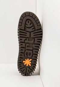Semelle de chaussure en caoutchouc noir avec des motifs de semelle profonds. Présente un logo en étoile orange près du talon. Surface texturée pour une meilleure adhérence.