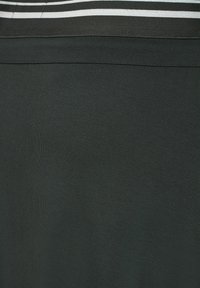 Mørkegrønt stof med en glat tekstur, der har vandrette sorte og hvide striber øverst. Simpelt, minimalistisk design.