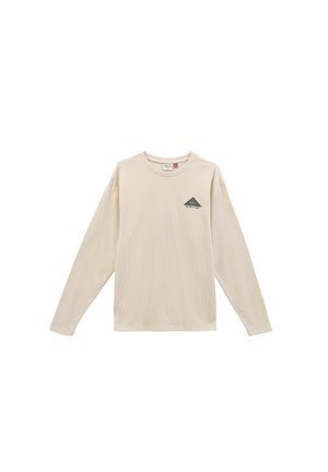 Long-sleeve cream shirt with a textured fabric, featuring a small dark triangle logo on the left chest area. Simple crew neckline.