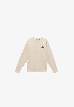Crème kleurige blouse met lange mouwen van gestructureerde stof, voorzien van een klein donker driehoekig logo op de linkerkant van de borst. Eenvoudige ronde halslijn.