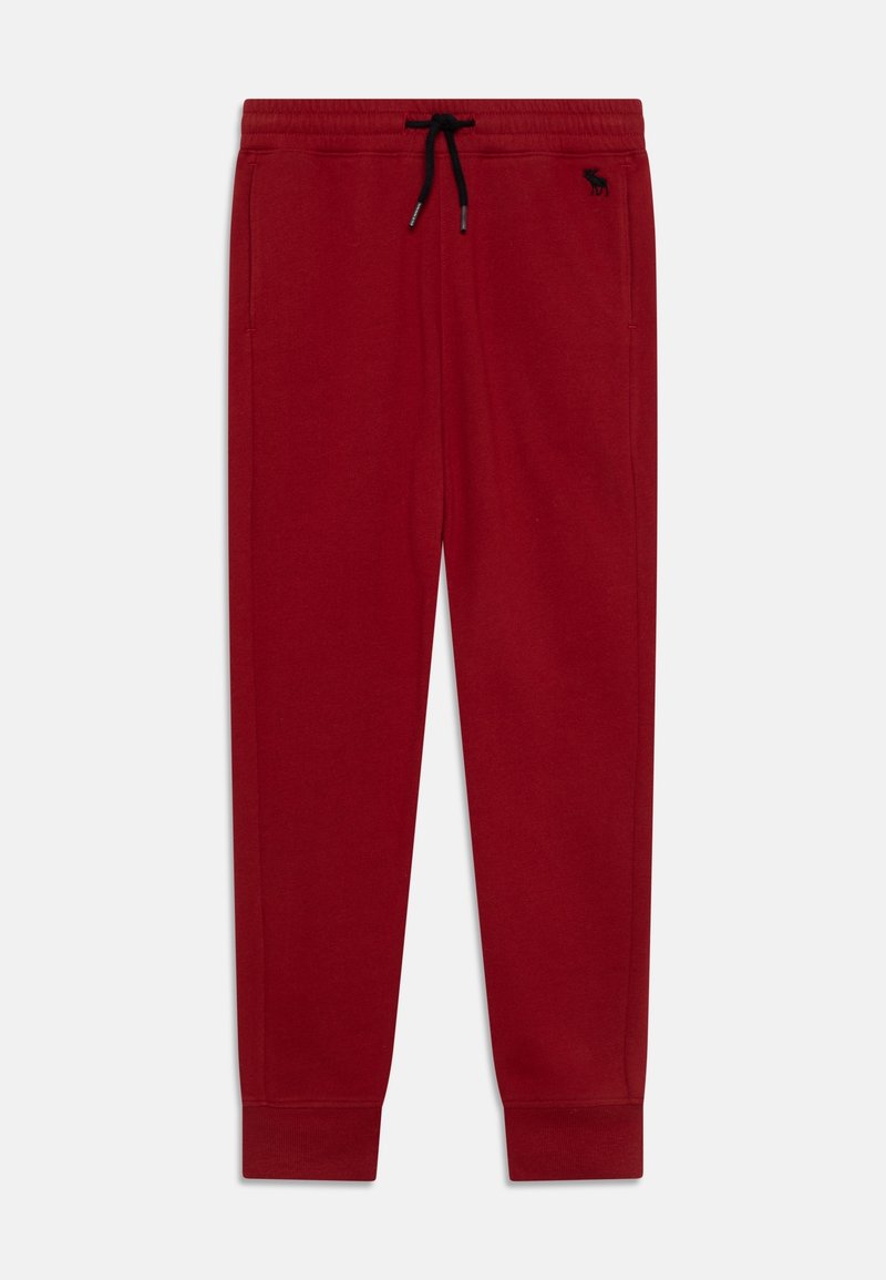 Red sweatpants made of soft fabric, featuring an elastic waistband with drawstring, ribbed cuffs, and a small logo on the left thigh.