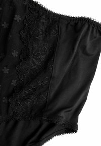 Zwarte lingerie met een geprofileerde mesh-paneel met bloemige kantdetails, gladde stof, golvende randen en elastische afwerking.