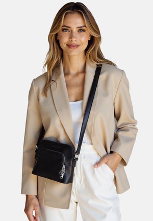 Borsa a tracolla in pelle nera con chiusura a zip, texture liscia, accessori in argento e tracolla regolabile. Le dimensioni suggeriscono un formato compatto.