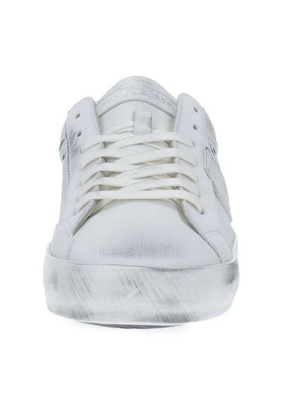 Sneaker bianco con tomaia sintetica liscia, punta rotonda e design con lacci piatti. Presenta una suola intermedia texturizzata e accenti di branding minimalisti.