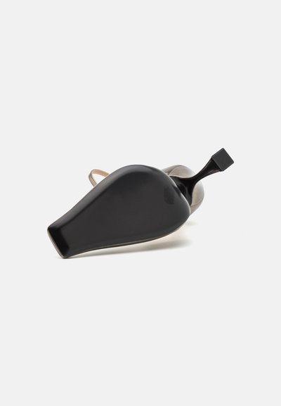 Zapato de tacón alto negro con punta afilada y tacón cuadrado. Presenta un acabado suave y una correa en un tono claro contrastante en el tobillo.