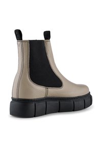 Botas Chelsea de cuero beige con paneles laterales elásticos en negro, acabado texturizado y suela de goma negra gruesa para mayor altura.