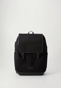 Μαύρο σακίδιο από καμβά με κάλυμμα φτερού, δύο λουριά εμπρός και μια τσέπη με λογότυπο στο μπροστινό μέρος. Διαθέτει πλαϊνές τσέπες και ματ φινίρισμα.