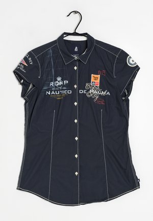 Navy blue short-sleeve button-up shirt with white stitching, nautical-themed logos, text, and patches, hanging on a black hanger.