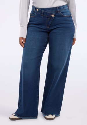 Breda denimjeans i mörkblått med en slät textur, med knappstängning och kontrasterande sömmar längs sömmarna och fållen.