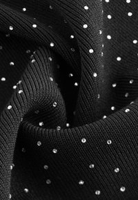 Schwarzer Stoff mit gerippter Textur, verziert mit gleichmäßig verteilten, kleinen transparenten Strasssteinen.