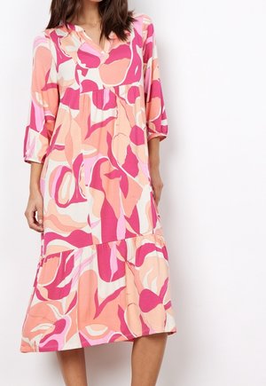 Sukienka midi w kwiatowy wzór w odcieniach różu, kremu i koralu. Posiada dekolt w serek, rękawy do połowy przedramienia oraz falbaniaste wykończenie u dołu. Miękka faktura materiału.