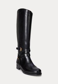 Black leather knee-high boot with a sleek design, featuring ankle straps and a gold buckle detail. Slightly textured finish and low heel.