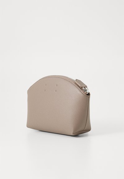Un pachet din piele maro cu fermoar, având un vârf rotunjit, o suprafață texturată și un design minimalist, cu cusături subtile pe față.