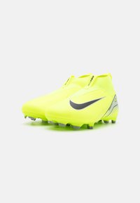 Des chaussures de football jaunes vives avec un design élégant et un logo noir en forme de virgule. Elles présentent un dessus texturé et une semelle distinctive pour une traction optimale.