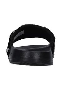 Sandalo nero con tallone arrotondato, cinturino testurizzato e soletta piatta. Presenta una finitura liscia e un materiale flessibile. Senza decorazioni visibili.