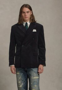 Navy double-breasted corduroy blazer met puntige revers, pochet, gecombineerd met versleten denim jeans met scheuren.