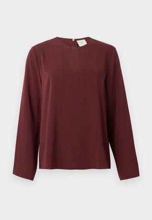 Bordowy blouse z długim rękawem, z małym dekoltem w kształcie łezki z przodu oraz ukrytym zapięciem na zamek z przodu kołnierza.
