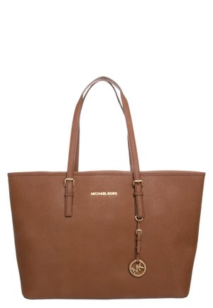 Brązowa skórzana torba typu tote Michael Kors z dwoma paskami na ramię oraz okrągłym metalowym breloczkiem z logo MK zawieszonym na prawym pasku.