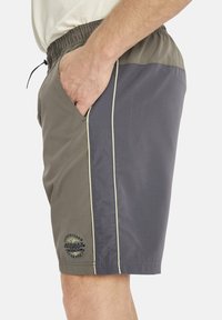 Herren Badehosen mit einem Grauton und dunklen Graufarbblockdesign, elastischem Bund, Seitentaschen und Logodetail am unteren Bein.