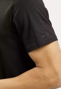 Czarna, krótko-sleeve T-shirt z gładkiego materiału. Posiada małe logo "CROSS" na rękawie. Slim fit, eksponująca część umięśnionego ramienia.