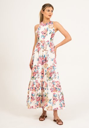Robe maxi florale à col haut, avec un fond blanc et des motifs colorés de roses et de fleurs bleues, avec un ourlet en couches.