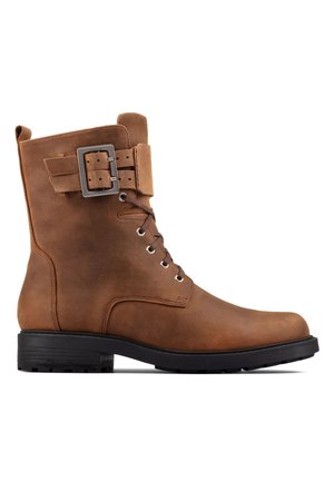 Brown leather ankle boot with a rounded toe, lace-up front, and a wide strap featuring a metallic buckle. Textured sole for traction.