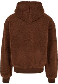 Felpa con cappuccio marrone in pile dalla superficie testurizzata, con cappuccio e polsini e orlo a coste. Caratterizzata da una vestibilità comoda e un tessuto morbido e peloso.