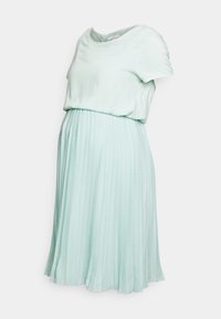 Robe de maternité plissée en vert menthe clair, avec un haut en jersey doux et une jupe fluide. Encolure ronde et manches courtes pour une simplicité élégante.