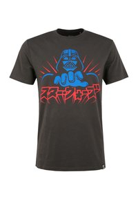 Camiseta de algodón negra con un gráfico en azul y rojo de una figura señalando, texto en caracteres japoneses y acentos de explosión en contraste.