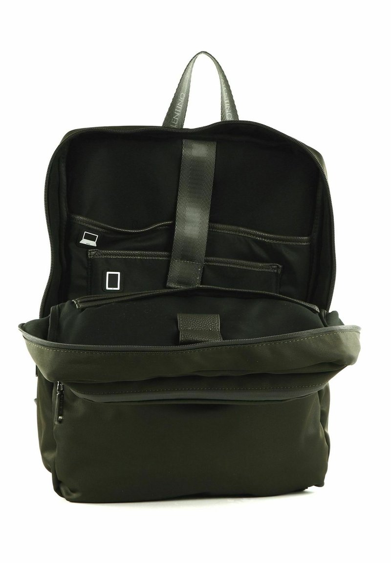 Mochila de tela negra con correas ajustables, múltiples bolsillos interiores y un compartimento frontal con cremallera. Presenta una textura suave y mate.