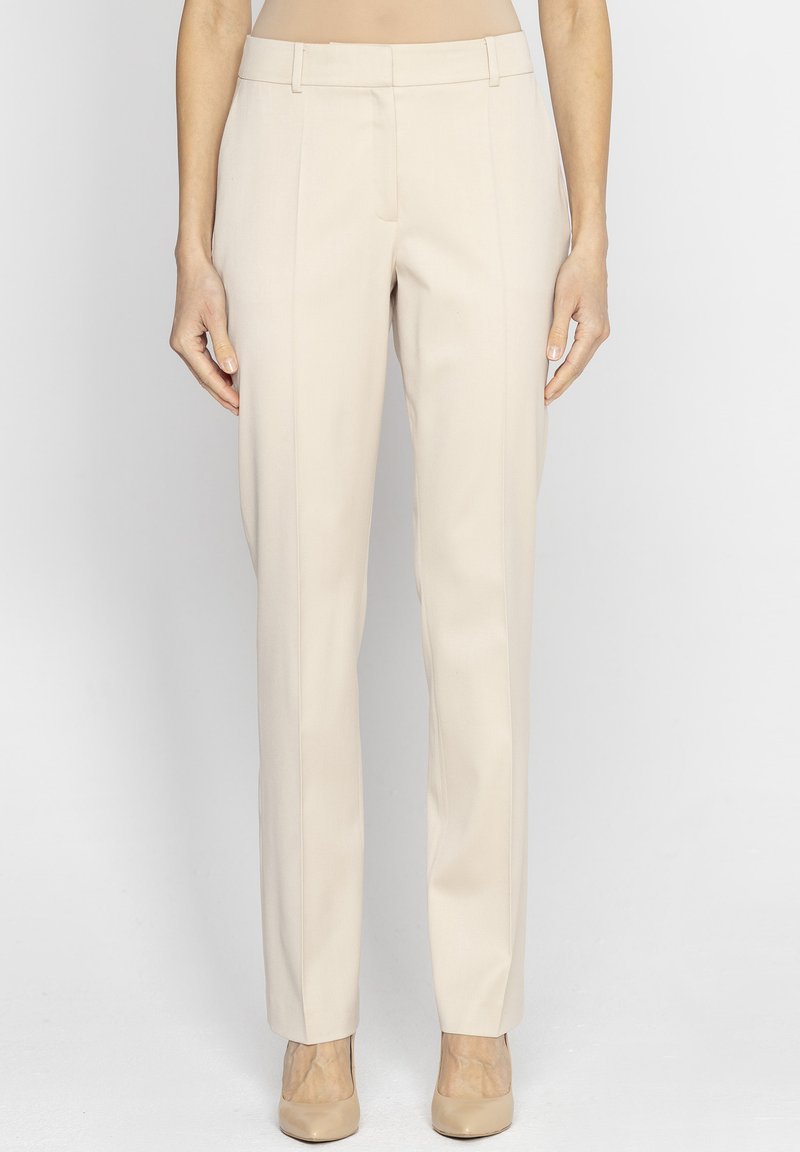 Beżowe spodnie o prostym kroju, wykonane z gładkiego materiału, z przegubami z przodu i średnim stanem.