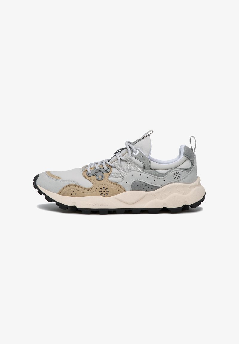 Sportschoenen met een combinatie van lichtgrijs, beige en donkergrijze materialen. Getextureerde bovenkant met perforaties, robuuste zwarte zool en veters.