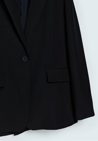 Blazer noir ajusté avec fermeture à un bouton, col cranté et poches à rabat en bas devant.