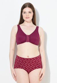 Bordeauxroter BH mit breiten Trägern und gerafftem Mittelteil, kombiniert mit passenden bordeauxroten, hochgeschnittenen Panties mit floralem Muster. Glatte Textur.