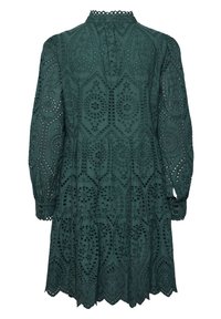 Dunkelgrünes Kleid mit kunstvollen Ausschnittmustern, langen Ärmeln und einem gestuften Saum. Der Stoff hat eine strukturierte Oberfläche und einen hohen Kragen.