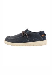 Chaussures slip-on en textile bleu marine, avec une tige en maille texturée et une semelle en caoutchouc crème. Des lacets marron ajoutent une touche de détail au design.