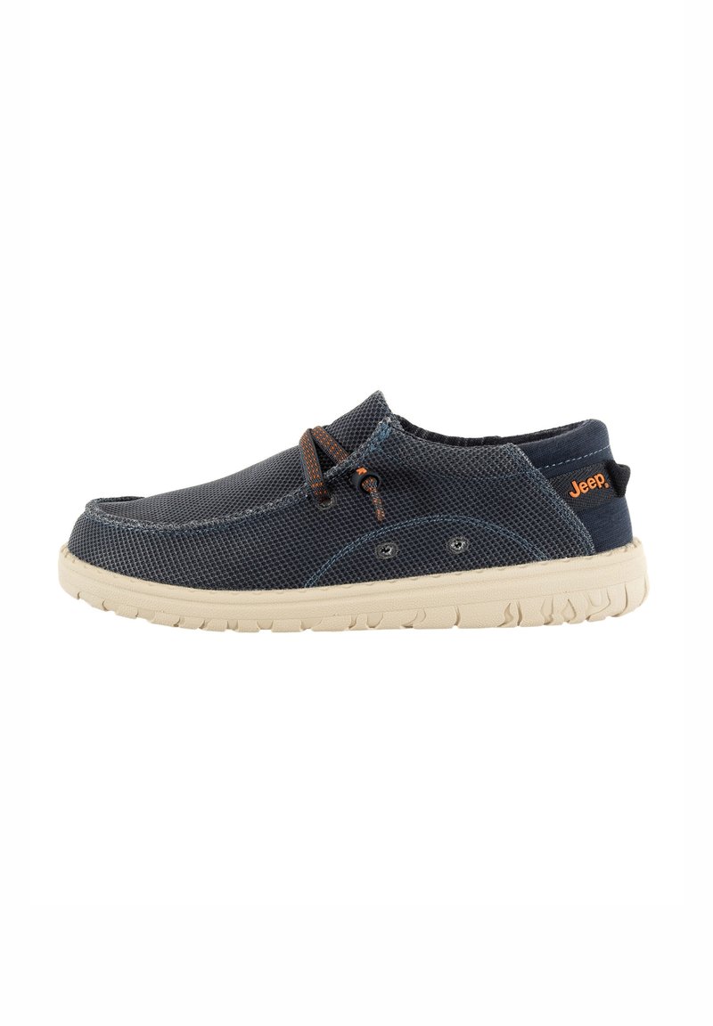 Chaussures slip-on en textile bleu marine, avec une tige en maille texturée et une semelle en caoutchouc crème. Des lacets marron ajoutent une touche de détail au design.