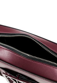 Borsa a mano in pelle borgogna con finitura texture, dotata di una cerniera argento e interno nero. Aperta per mostrare lo spazio interno.