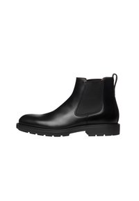 Bottine Chelsea en cuir noir avec panneaux latéraux élastiques, languette, bout rond et semelle en caoutchouc texturée. Fini lisse avec des coutures minimales.