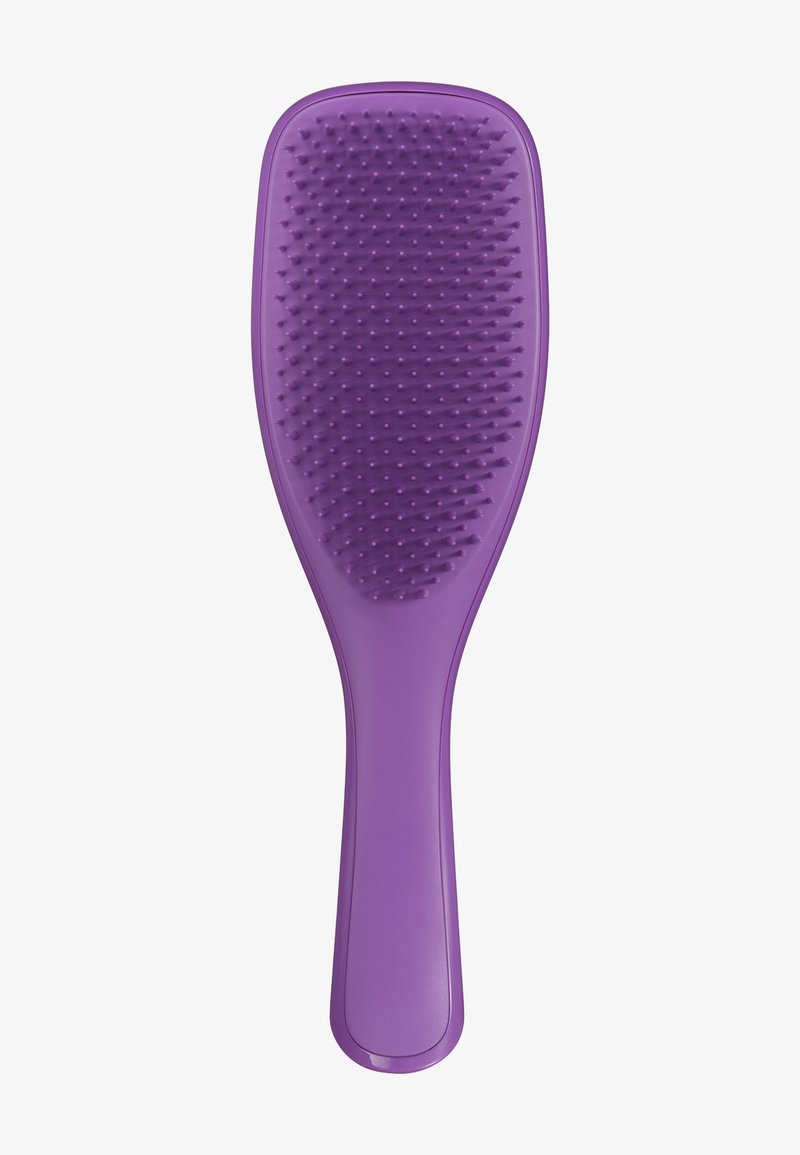Brosse à cheveux en plastique violet avec des poils courts et flexibles, et un manche lisse et contourné sur un fond blanc.