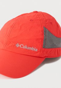 Κόκκινο καπέλο από ελαφρύ ύφασμα με κυρτό γείσο, που διαθέτει γκρι πλέγμα σε πάνελ και κεντημένο λογότυπο "Columbia" στο μπροστινό μέρος.