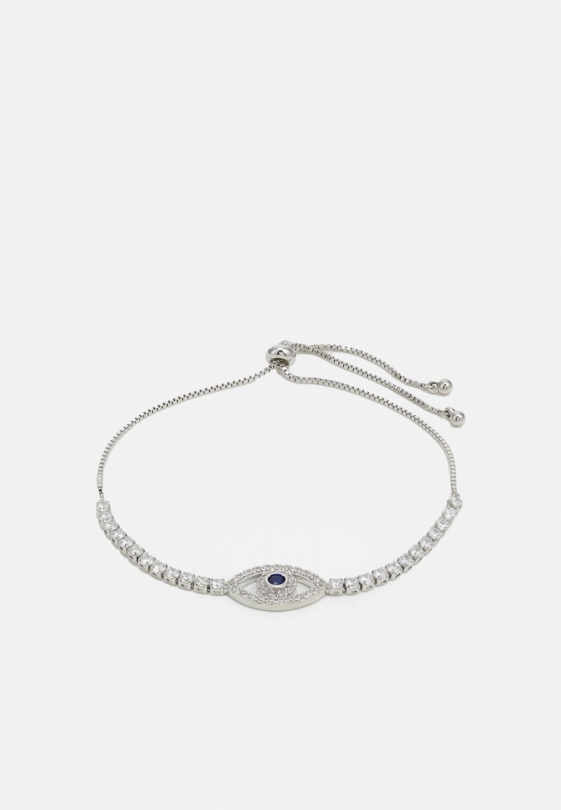 Bracelet réglable en argent avec des pierres claires et un pendentif en forme d'œil avec une pierre bleu foncé centrale sur un fond uni.