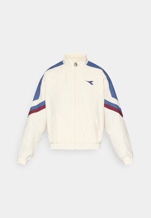 Weißes Jacket mit blauen und kastanienbraunen Akzenten, mit Reißverschluss vorne, hohem Kragen, elastischen Bündchen und Saum. Mit einem Logo auf der linken Brust.