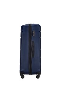 Navy-Hartschalenkoffer mit strukturiertem Finish, vertikalen Rillen, schwarzem Reißverschluss und Beschlägen, seitlichem Griff und vier Rollen für Mobilität.