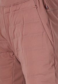 Gevoerde, lichtgewicht broek in zachte, gedempte roos met een gladde textuur, voorzien van zijzakken en een elastische tailleband voor comfort.